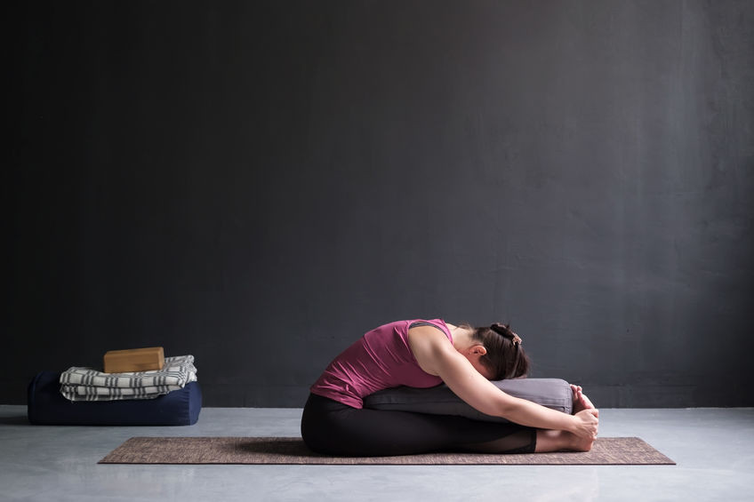Réalisea Paschimottanasana en utilisant des accessoires de yoga Paschimottanasana :avec des accessoires de yoga